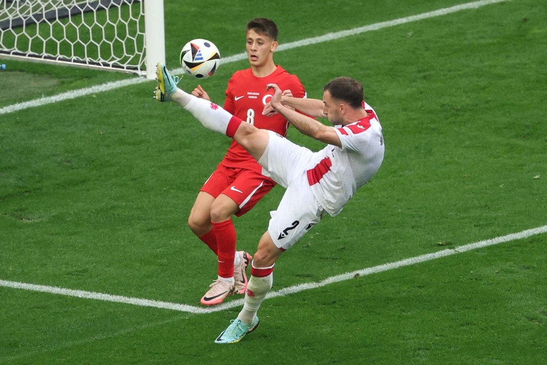 El georgiano Otar Kakabadze (d) despeja el balón ante el joven jugador de Turquía Arda Güler en Dortmund, Alemania. EFE/EPA/FRIEDEMANN VOGEL