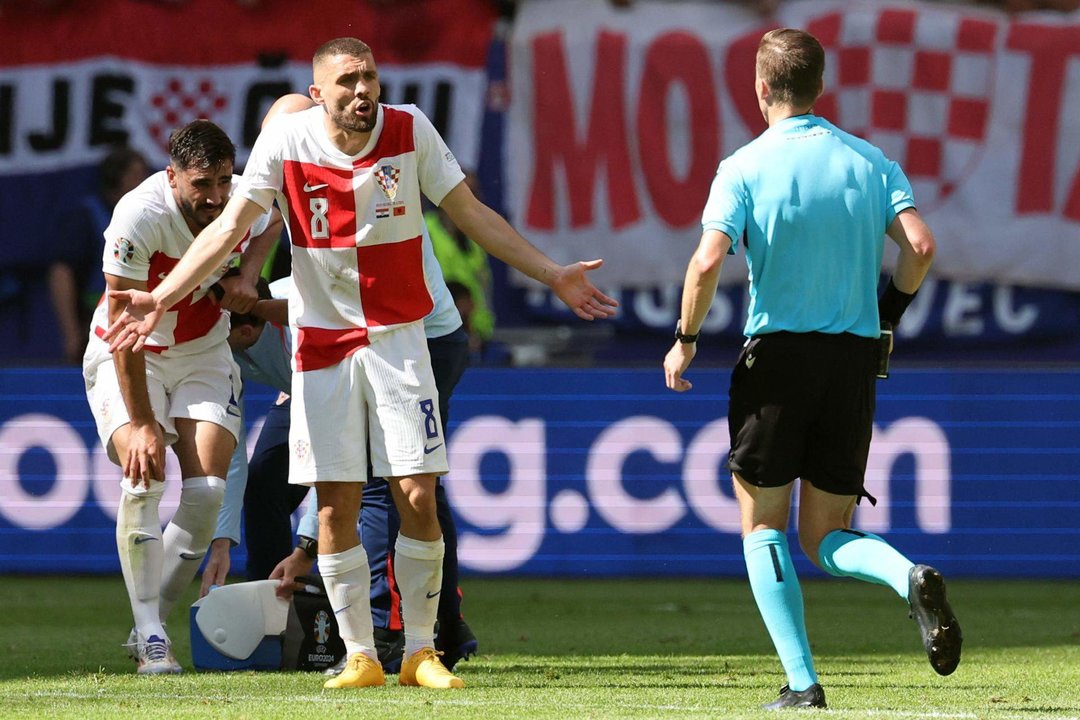 El croata Mateo Kovacic habla con el árbitro Francois Letexier en Hamburgo, Alemania. EFE/EPA/ABEDIN TAHERKENAREH